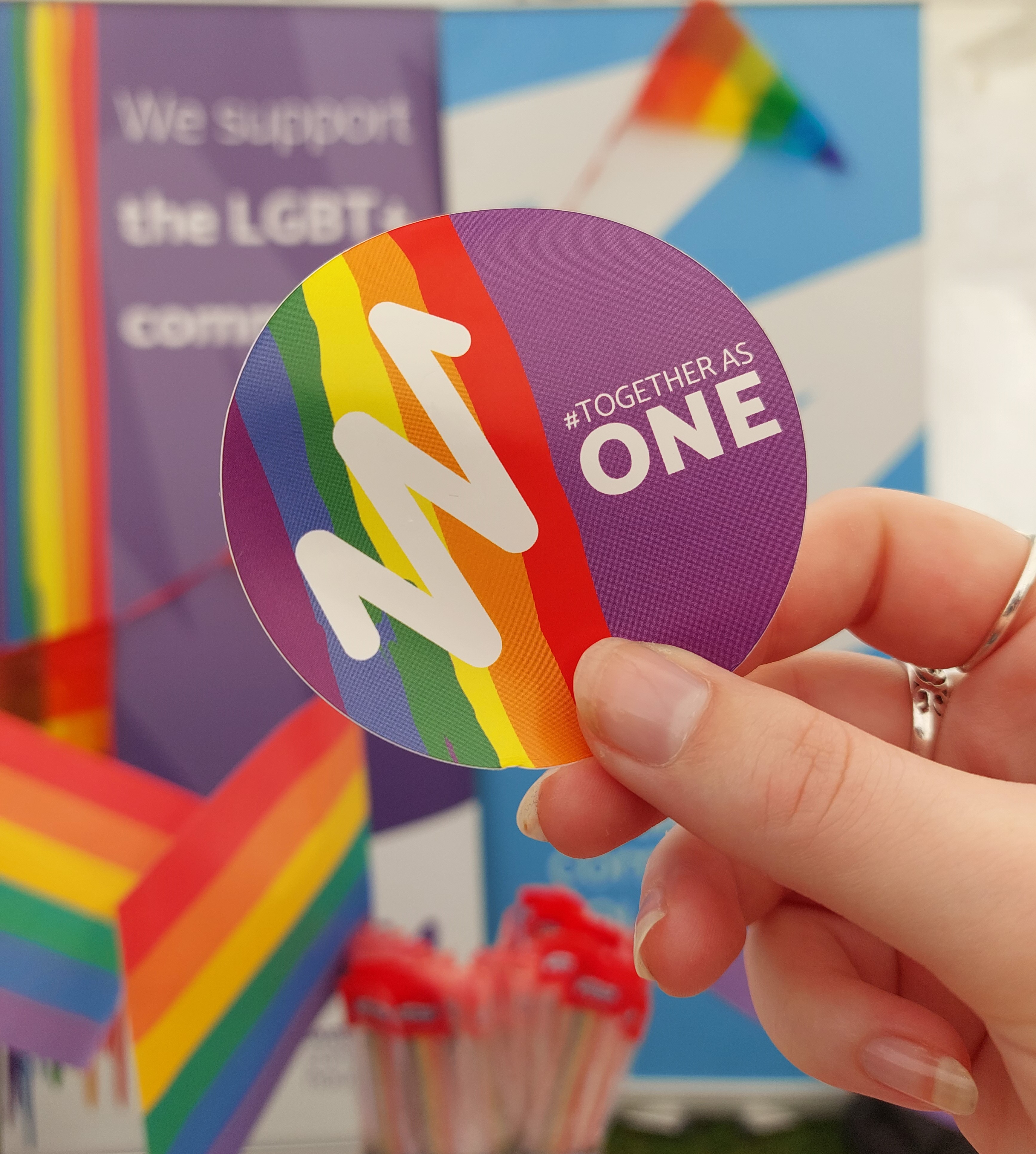 A sticker with the pride flag which reads together as one