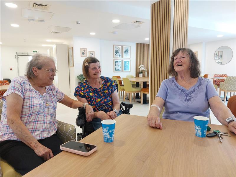 Three residents of Robin House sitting in the common area