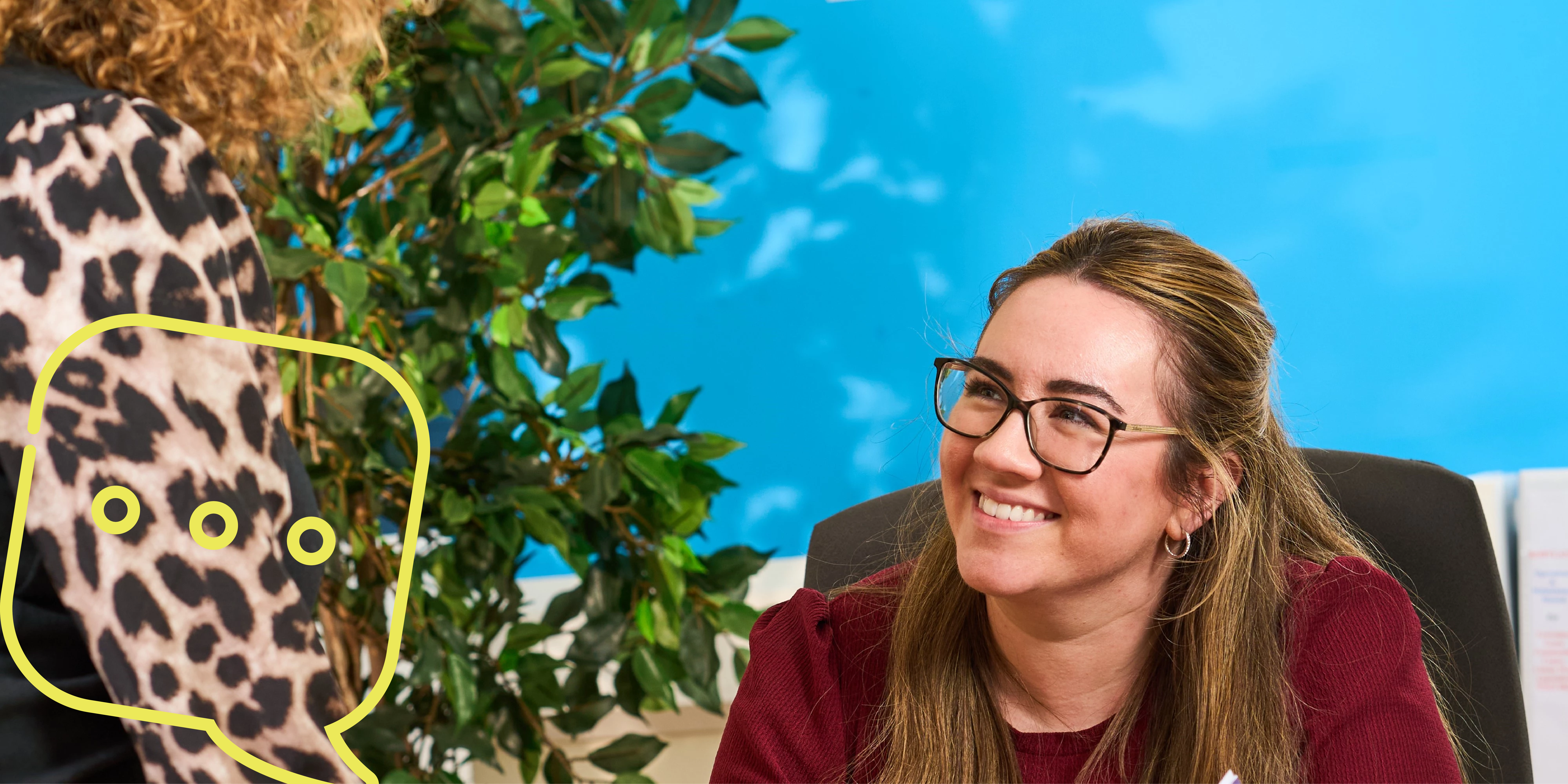 two women talking at a reception desk