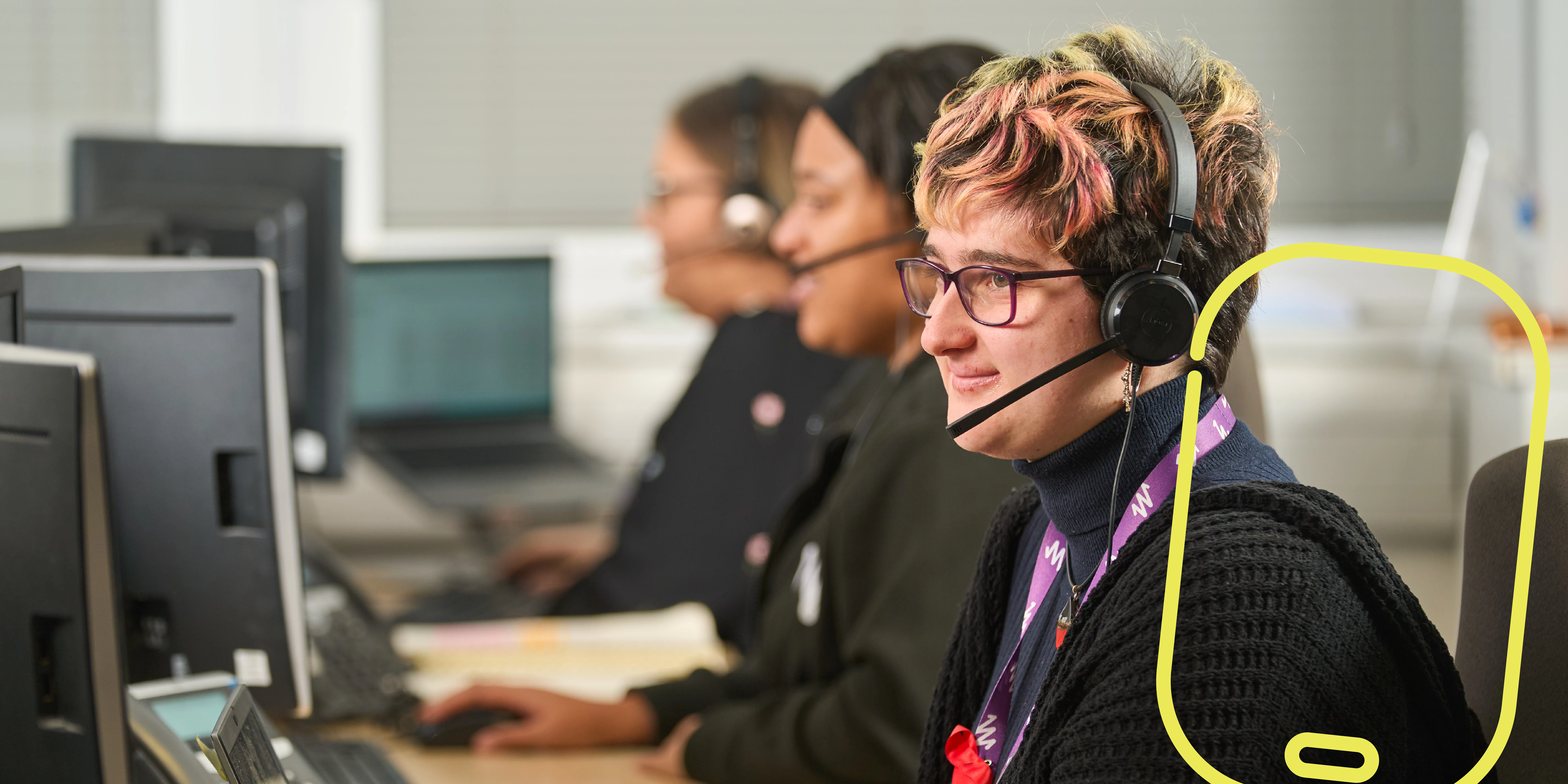 Young woman sitting at a desk and talking on a headset
