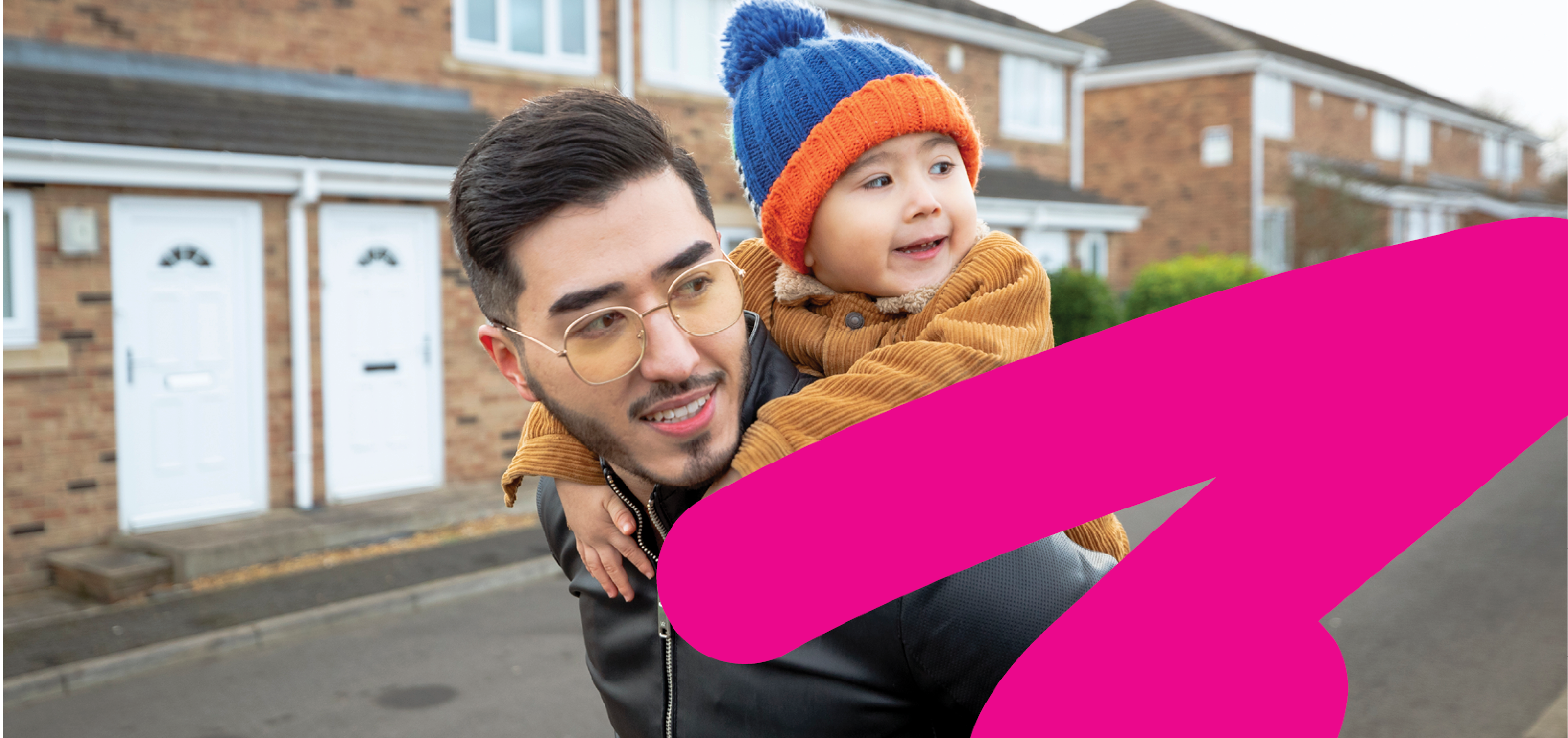 Young mixed race father giving infant son a piggy back