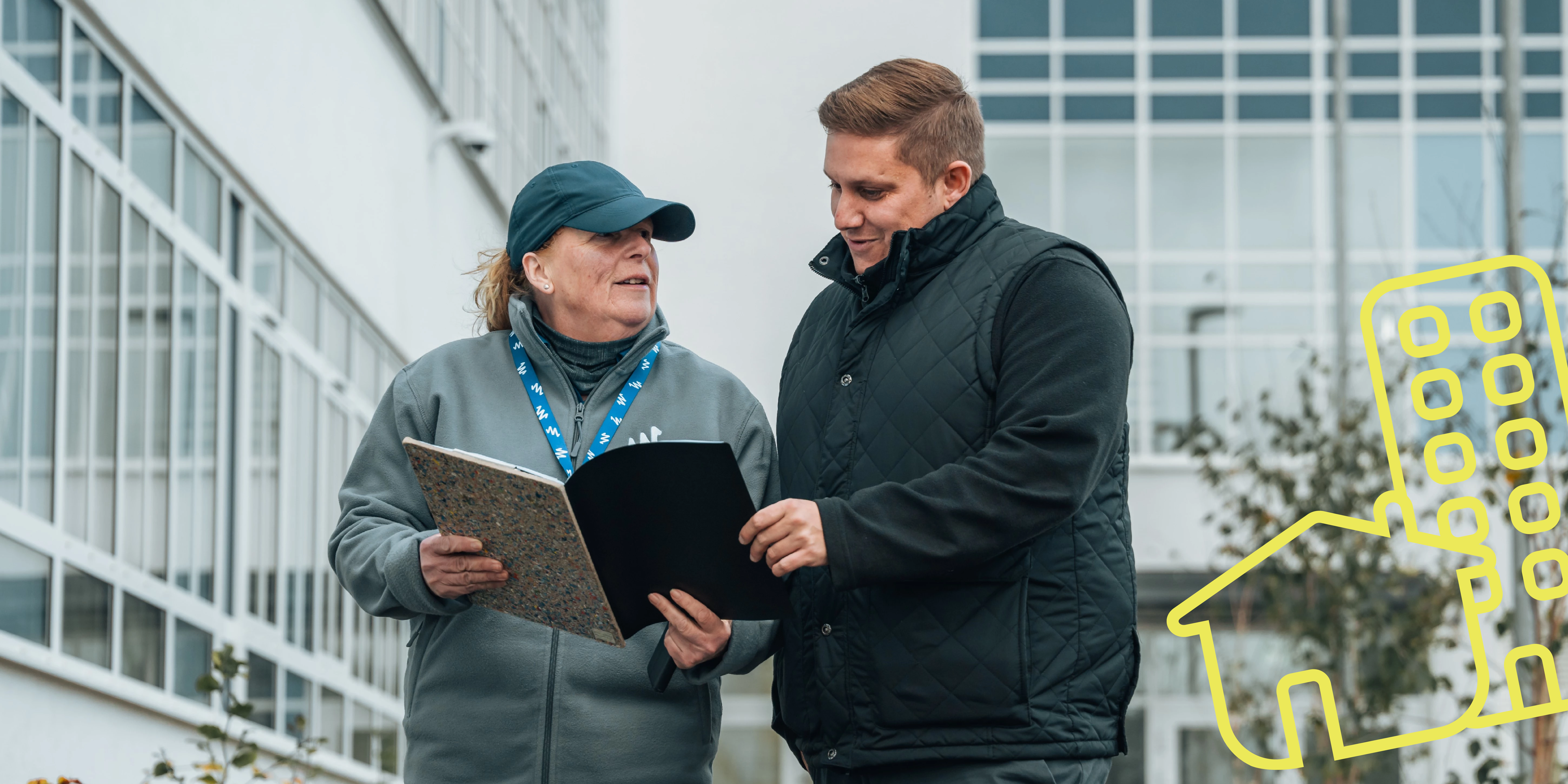 Two people inspecting a building's design plan
