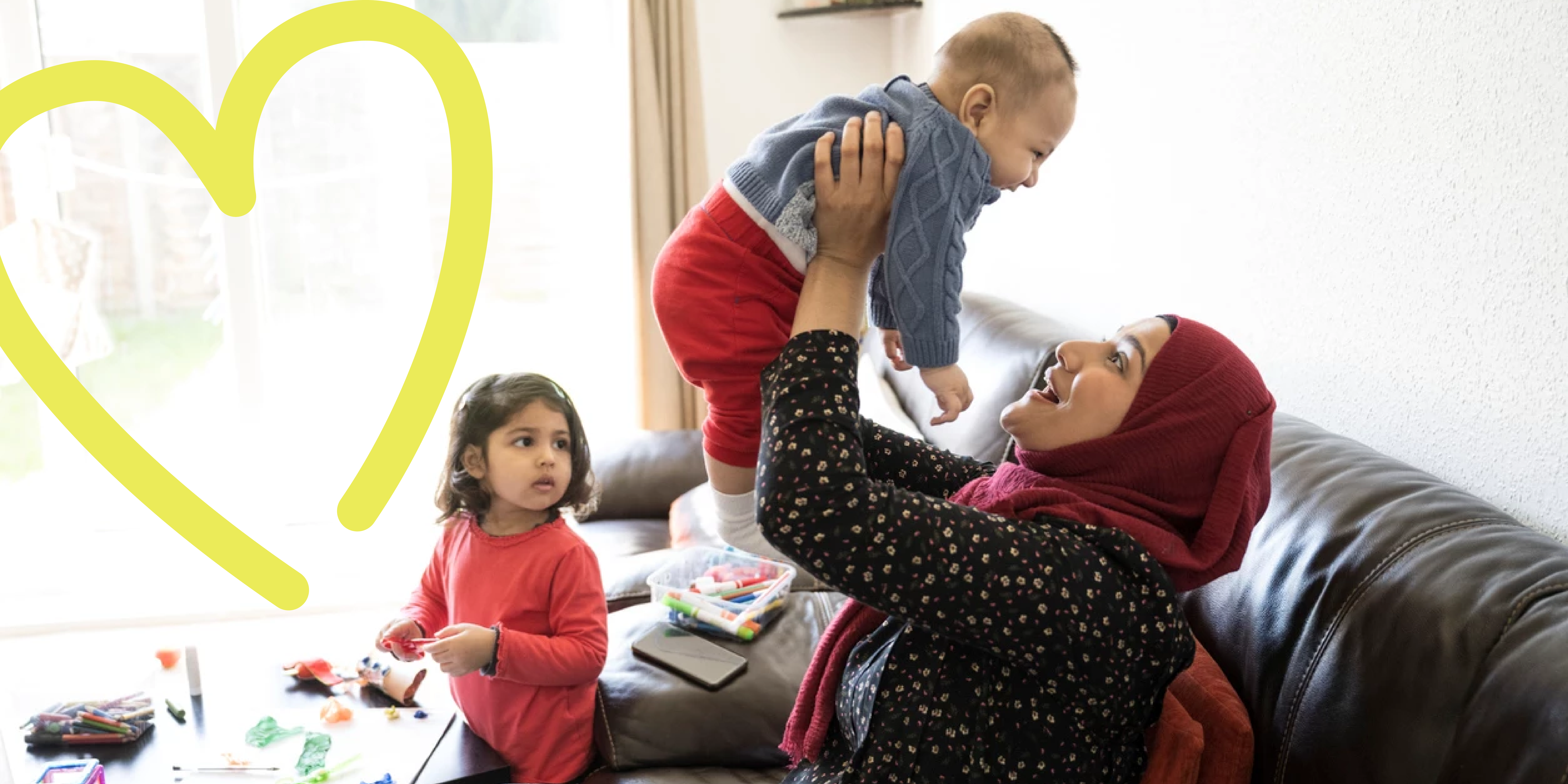 Young asian mother holding baby boy with infant daughter looking on
